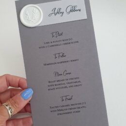 grey modern mongram personalised menu with white wax seal and vellum tag 260x260