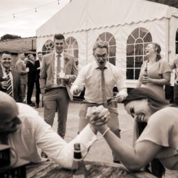 wedding guests cheer arm wrestling manor farm barn.jpg 260x260