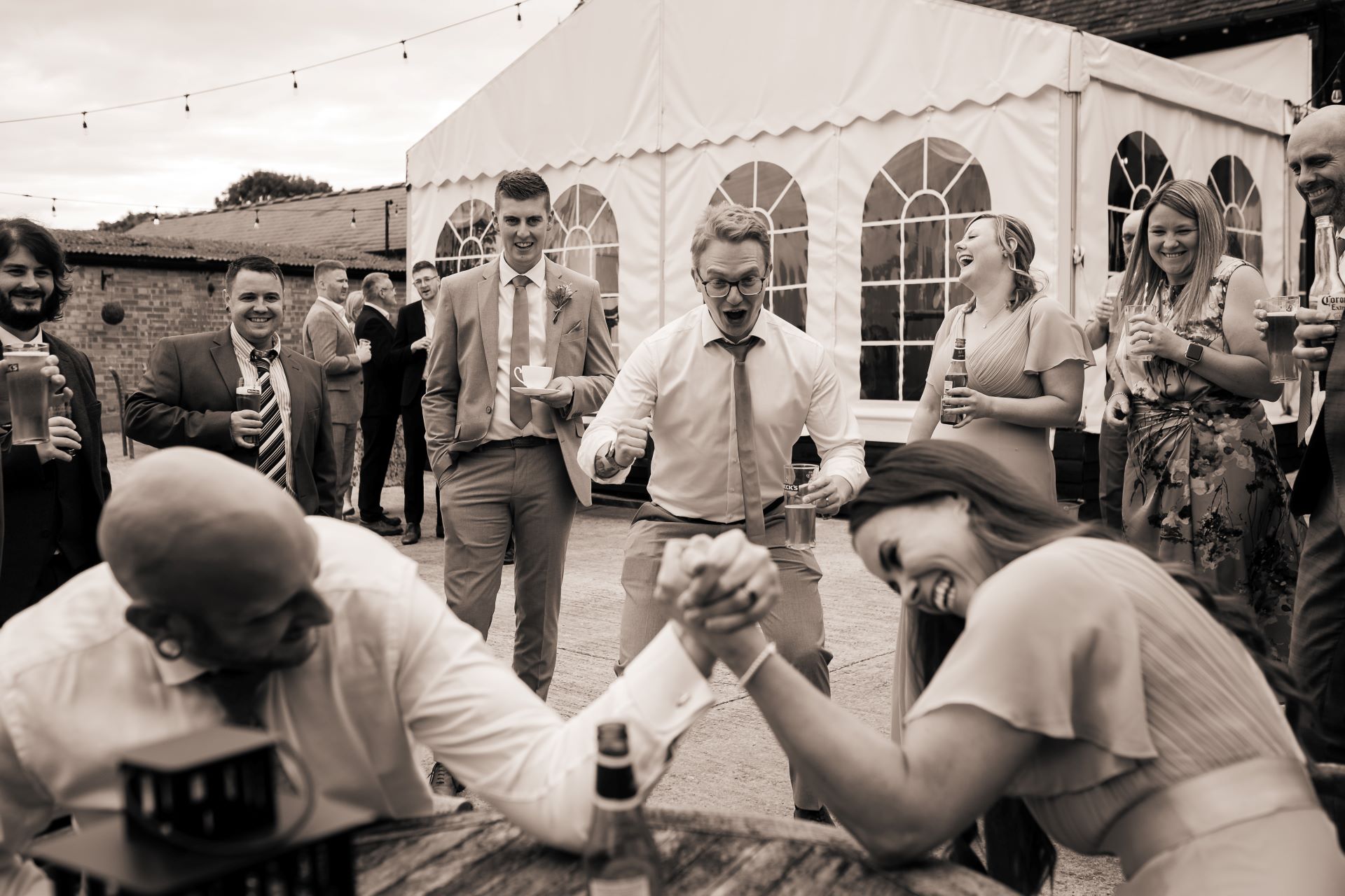 wedding guests cheer arm wrestling manor farm barn.jpg